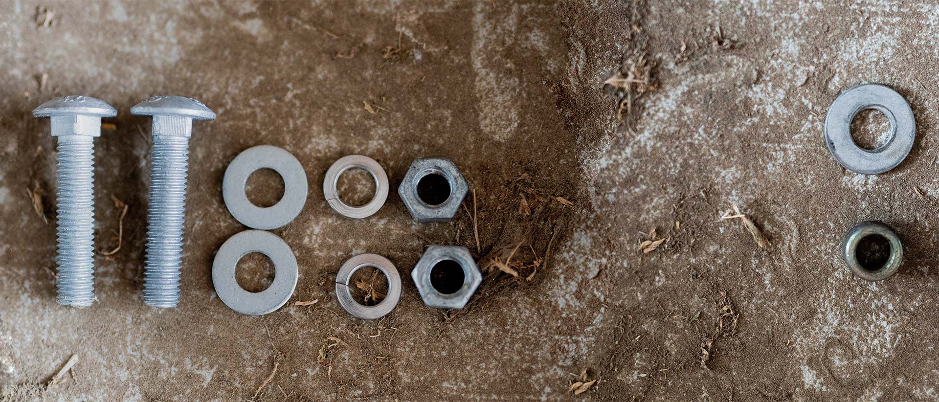 Nuts, bolts and washers on a dirty concrete floor